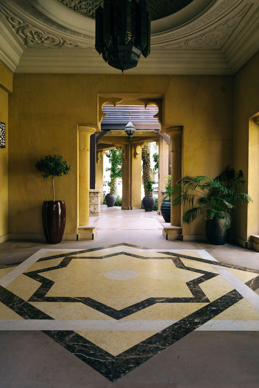 Moroccan-style entrance hall with carved ceiling and zellige floor