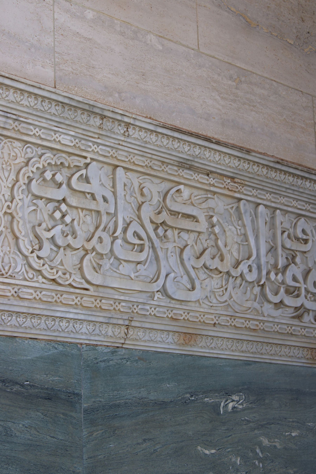 Arabic calligraphy carved in stone on a wall in Rabat