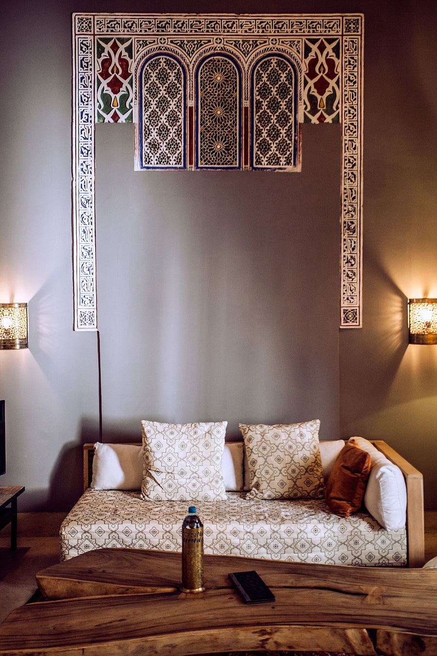 Cosy living room with sofa, cushions and wall lamps