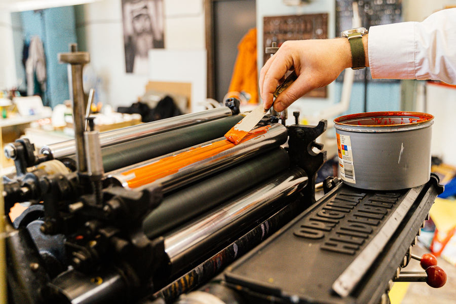 Ink being applied to the roller of a vintage printing press